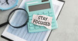 Stay focused text concept write on paper on calculator