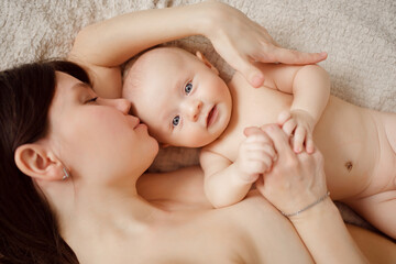 Wall Mural - a naked mother and the baby on the bed. maternal and child health. 