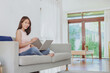 © interstid - Beautiful Asian woman working with laptop notebook at home on sofa