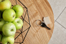 Key From House And Basket With Apples On Wooden Table In Room