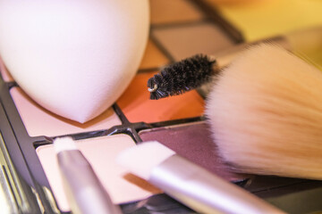 Colorful palette of eyeshadows and blushers. Professional makeup brushes and tools on white background