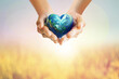Human Hands holding Earth ball in heart shape on pastel background for World Health Day content and copy space.Elements of this image furnished by NASA