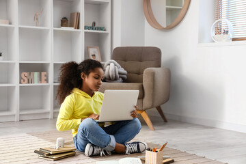 Canvas Print - Little African-American girl studying with online tutor on floor at home