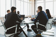© xartproduction - Group of young business people working and communicating while sitting at the office desk together with colleagues sitting. business meeting