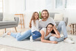 © Pixel-Shot - Young family on soft carpet at home