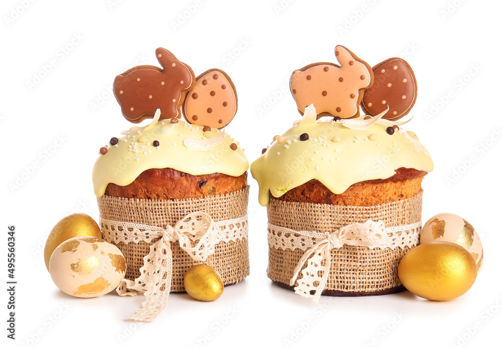 Delicious Easter cakes decorated with cookies and painted eggs on white background