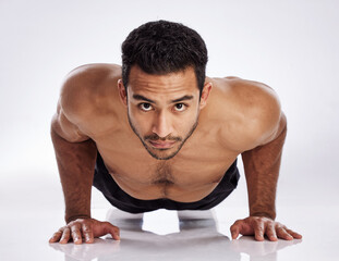 Wall Mural - The best exercise for toned arms. Shot of a young man practicing push ups against a studio background.