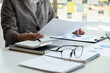 © Natee Meepian - Accountant bookkeeper or financial inspector hands making report, calculating. Home finances, investment, economy, saving money or insurance concept