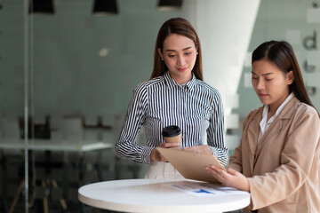 Wall Mural - Group of asian businesswoman and Accountant checking data document on paperwork chart report for investigation of corruption account