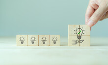 Suggestion And Consulting Concept. New Idea, Solution. Putting Wooden Cubes With Light Bulb On Hand Icon On Beuatiful Grey Background And Copy Space. Business Review, Strategy Suggestion For Busines