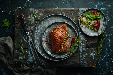 grilled marbled beef steak tenderloin. On a black stone background.