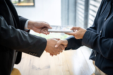Wall Mural - Businessman shaking hands to receive banknote money and terms of contract from bribe employer in signing contract