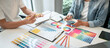 © Freedomz - Two creative graphic designer working on color selection and drawing on graphics tablet at workplace, Color swatch samples chart