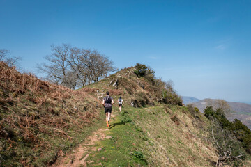 Wall Mural - Dois jovens a correr numa das trilhas da montanha Jara em Irouléguy no País basco