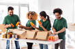 © Syda Productions - charity, donation and volunteering concept - international group of happy smiling volunteers packing food and drinks in boxes at distribution or refugee assistance center