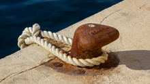 Closeup Shot Of An Old Rustic Mooring Bollard With Rope On The Harbor