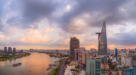 Aerial view of Bitexco Tower, buildings, roads, Thu Thiem 2 bridge and Saigon river in Ho Chi Minh city - Far away is Landmark 81 skyscrapper. This city is a popular tourist destination of Vietnam