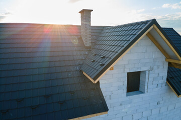 Wall Mural - Aerial view of unfinished house with aerated lightweight concrete walls and wooden roof frame covered with metallic tiles under construction