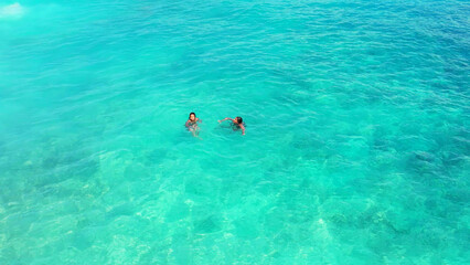 Poster - Aerial Shot girls swim in the turquoise, clear water of Gili Meno Island, Lombok, Indonesia.