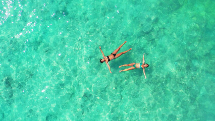 Poster - Aerial Shot girls swim in the turquoise, clear water of Gili Meno Island, Lombok, Indonesia.