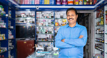 Portrait Shot Of Happy Medical Shop Owner Standing With Crossed Arms By Looking At Camera At Pharmacy - Concept Of Successful, Small Business And Occupation.