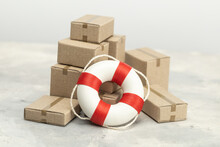 Cardboard Boxes For Delivery And Lifebuoy. Concept Of Assistance In Parcel Delivery Or Insurance