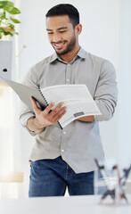 Poster - The numbers are looking good this month. Shot of a young man reading a document at work in a modern office.