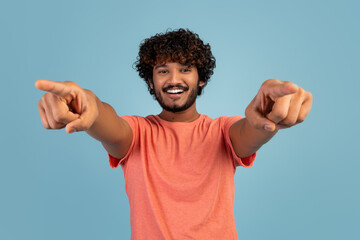 Wall Mural - Cheerful curly eastern guy pointing at camera