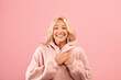 © Prostock-studio - Grateful lady holding hands on her chest, expressing gratitude, posing over pink studio background and smiling at camera