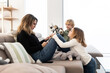 © ADDICTIVE STOCK - Children near mother browsing tablet on couch