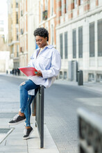 Smiling Black Woman Reading Documents On Street