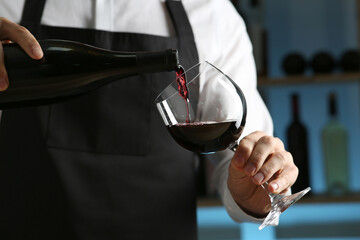 Poster - Bartender pouring wine into glass in restaurant, closeup