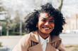 © Dani D.G - Portrait of happy woman in coat in park looking away