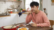 © PR Image Factory - sad single asian male having lunch alone during the day in the dining room at home. he stops eating and props head, thinking about his family and friends.