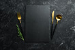 Table setting. Slate black stone plate with cutlery. Top view. Free copy space.
