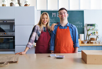 Wall Mural - Young Down Syndrome waiter working with colleague in take away restaurant, social inclusion concept.