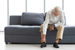 © offsuperphoto - senior man suffering from knee ache on sofa
