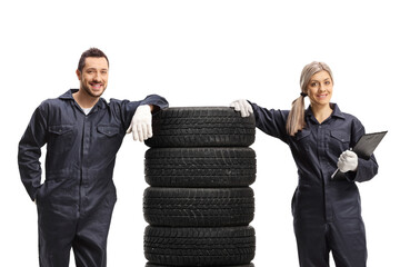 Canvas Print - Male and female auto mechanics with a pile of tires