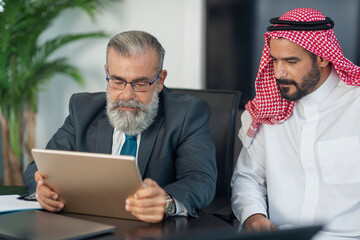 business meeting in the office, arabian businessman having a business conversation with a mature bus