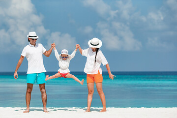 Happy family of three having fun together on the beach