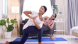 © comzeal - Young Asian woman yoga instructor teaching yoga practices at home