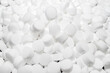 Background made of salt tablets for a water softener, large round cubes.