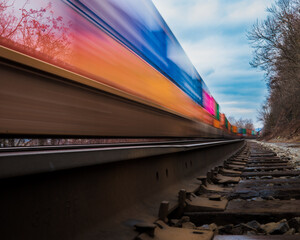 Closeup shot of the moving train on the railroad against a cloudy sky in winter