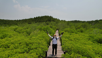 Wall Mural - Portrait A man tourist  travel to Mangrove forest , study natural and environment , Tung Prong Thong Forest located at Pak Nam Prasea in Rayong of Thailand