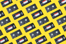 VHS Video Cassette, Old Black Videotape Pattern On A Yellow Background, Outdated Technology Background.