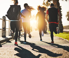 Poster - Having someone to motivate you makes all the difference. Rearview shot of a fitness group out running on the promenade.