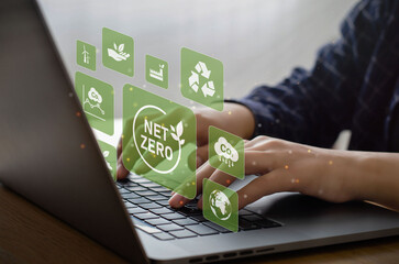 Businessman using computer to manage online information about net zero concept. natural environment neutral carbon A climate-neutral long-term strategy greenhouse gas emissions targets