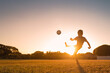 © kieferpix - Silhouette of child boy playing football kicking ball