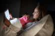© Koegelenberg/peopleimages.com - Its Moms way of bonding while browsing. Shot of a mother using a digital tablet while her baby sleeps on her chest at home.
