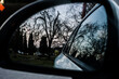 Autumn park at sunset reflected in the car side-view mirror
